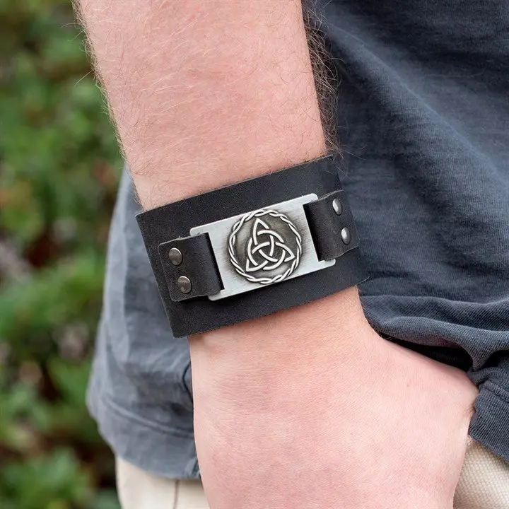 Black leather cuff bracelet with a metal Celtic triquetra knot centrepiece