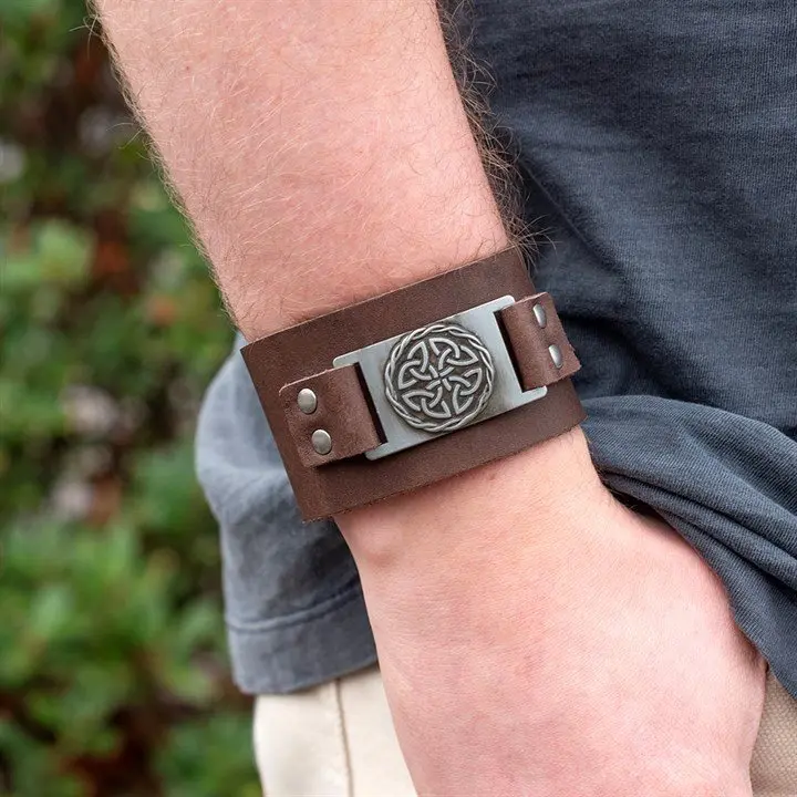Brown leather cuff bracelet with a metal Celtic shield knot