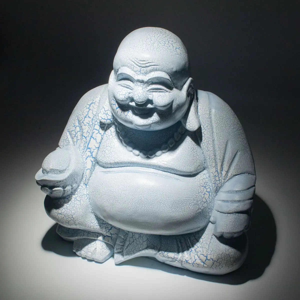 Glass Laughing Buddha lamp with a crackle finish on a round stand