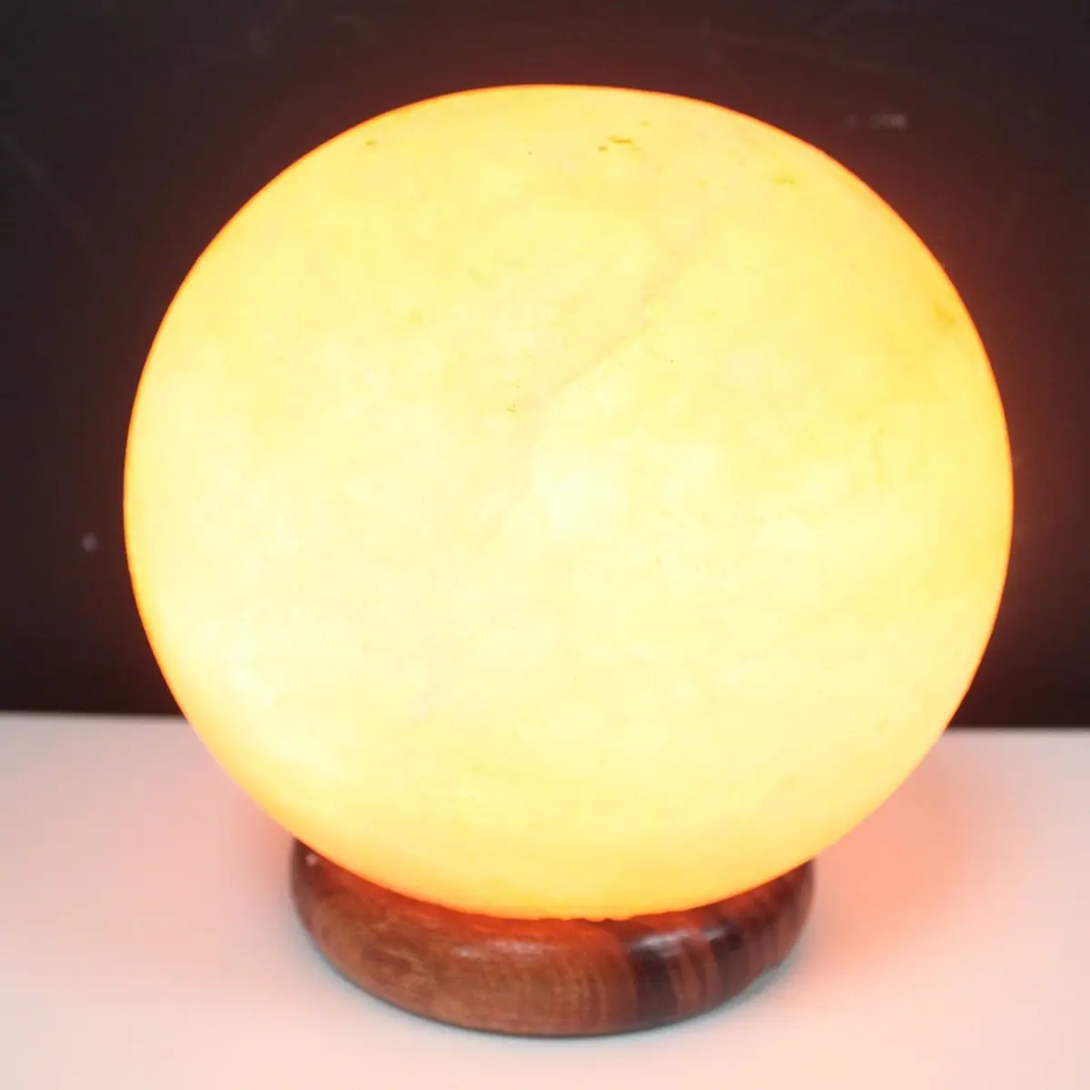 Himalayan salt lamp ball on a big wooden base