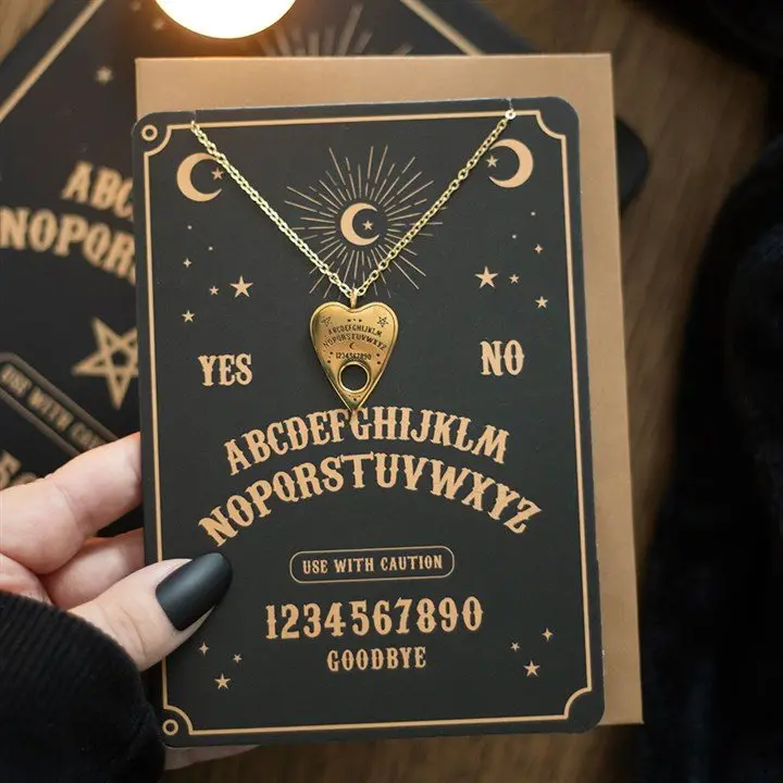 Gold planchette necklace on a talking board greeting card